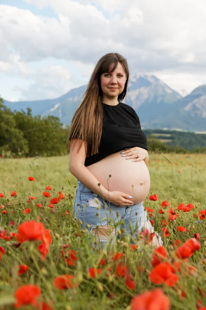 Photographe grossesse : femme enceinte dans un champ de coquelicots en Isère