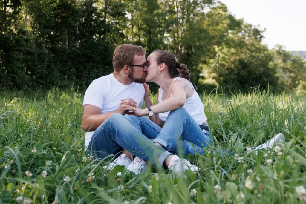 deux amoureux s'embrassent dans un champ