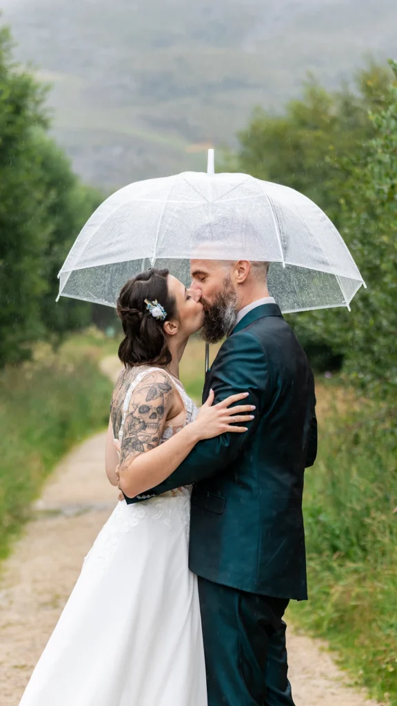 deux mariés sous un parapluie transparent