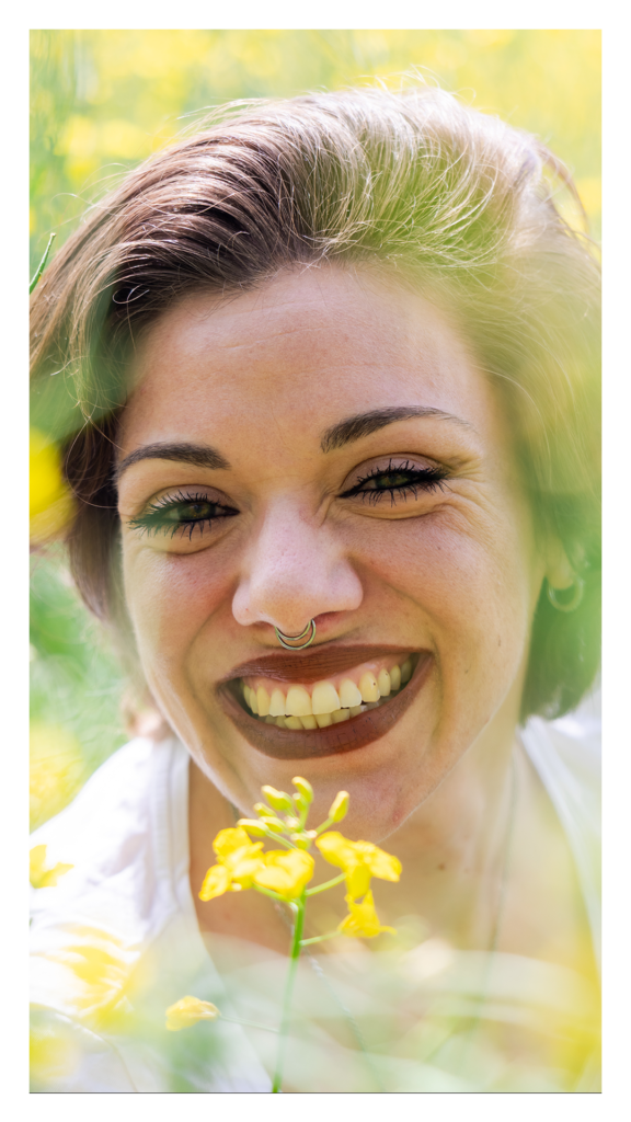 Gros plan portrait femme qui rit dans les colzas, style spontané, Isère