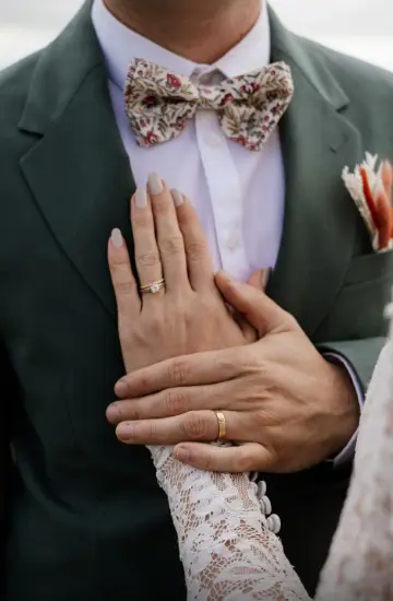 Détail alliances mariage style moody, contrastes forts, tons ocre et ombres denses.