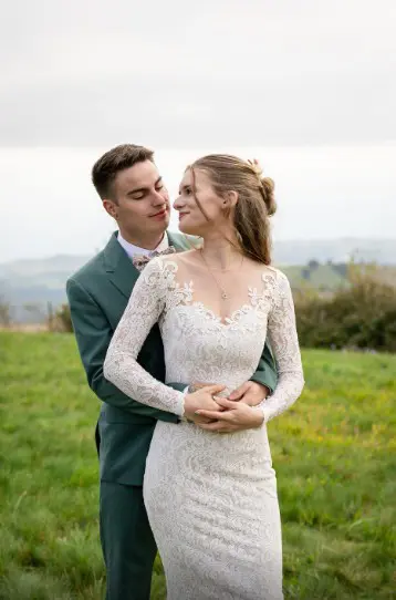 Couple de futurs mariés en extérieur, herbes hautes, teints naturels et clarté maximale.