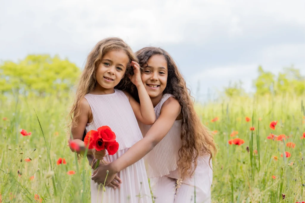 Portrait serré de deux sœurs dans les coquelicots, Isère printemps