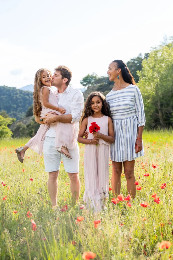 Famille dans les coquelicots avec les montagnes de l'Isère en arrière-plan
