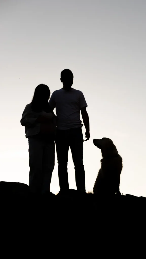 Silhouette couple et golden retriever au crépuscule, lac Besson, Alpe d'Huez Isère