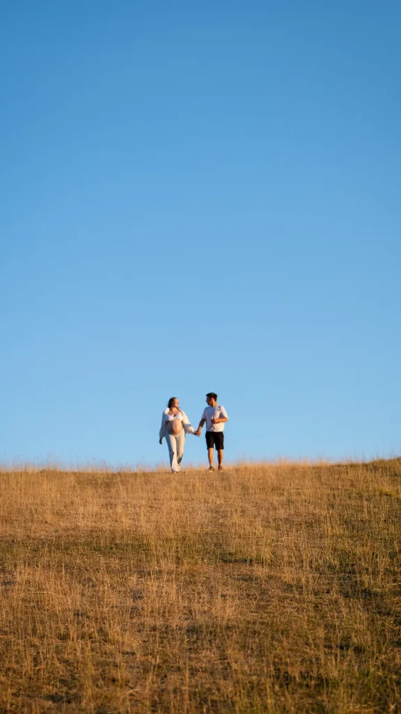 Futur couple marchant l'un vers l'autre dans un vaste champ d'alpage